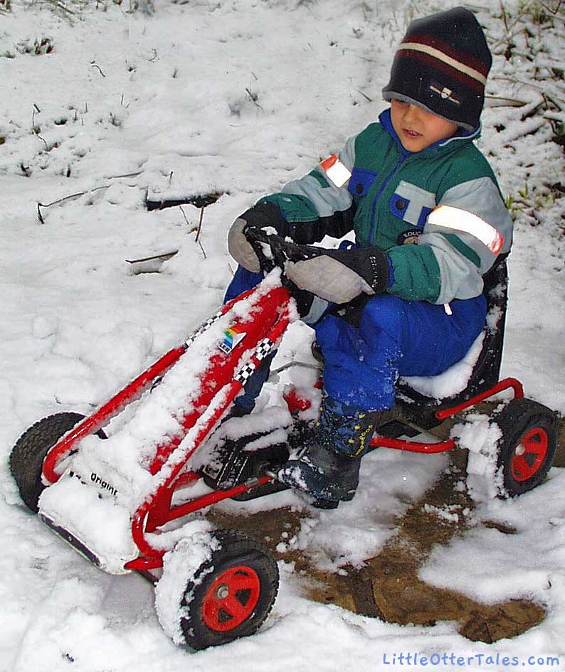 boy on peddle car in snow